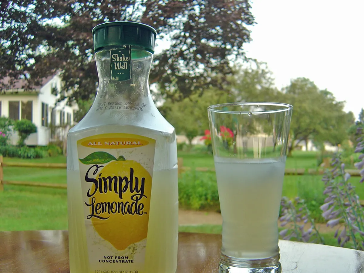 Bottled juice drink beside a filled glass