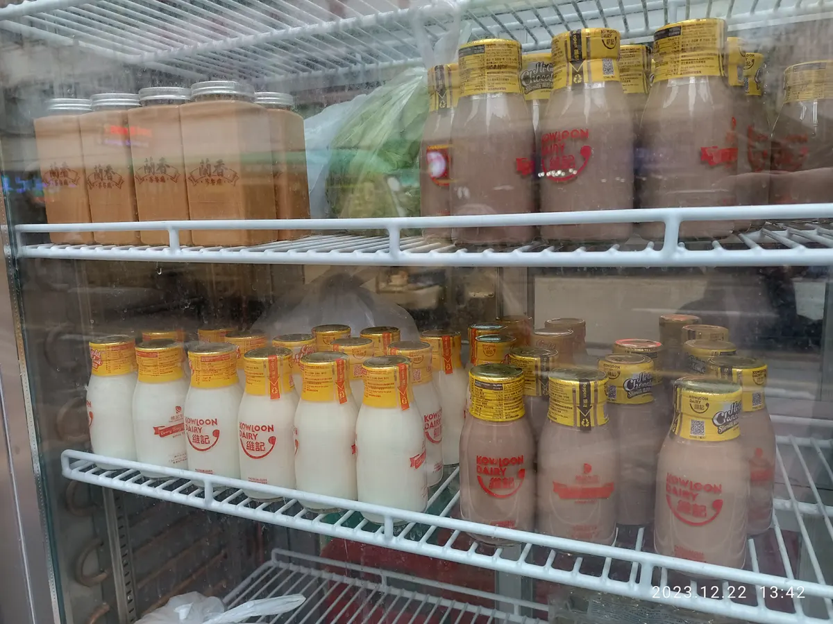 Chilled milk drinks in bottles on refrigerated shelving